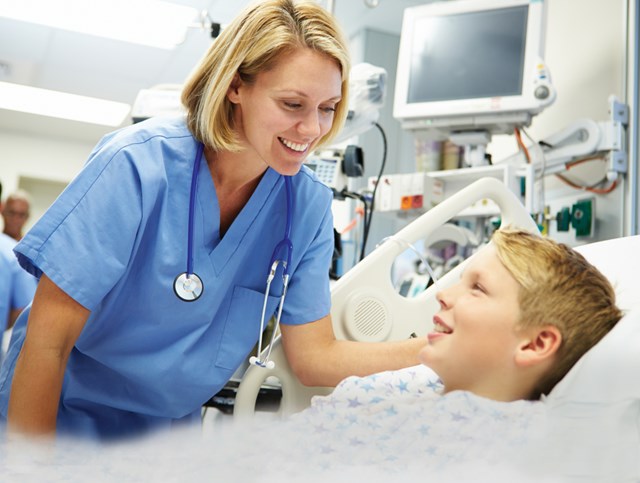 Female medical personnel at child patient bedside